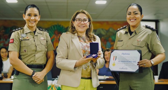 #PraTodosVerem: Na fotografia aparecem três mulheres em pé, posando; uma delas segura um diploma...