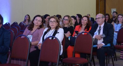 #PraTodosVerem: Na fotografia, aparece uma sala de conferência com várias pessoas sentadas em ca...