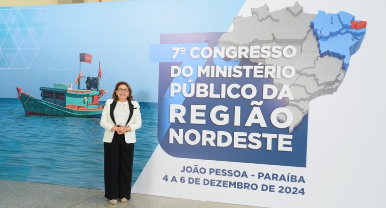 #PraTodosVerem: Na fotografia, aparece um mulher em pé, posando, com o banner do evento ao fundo.