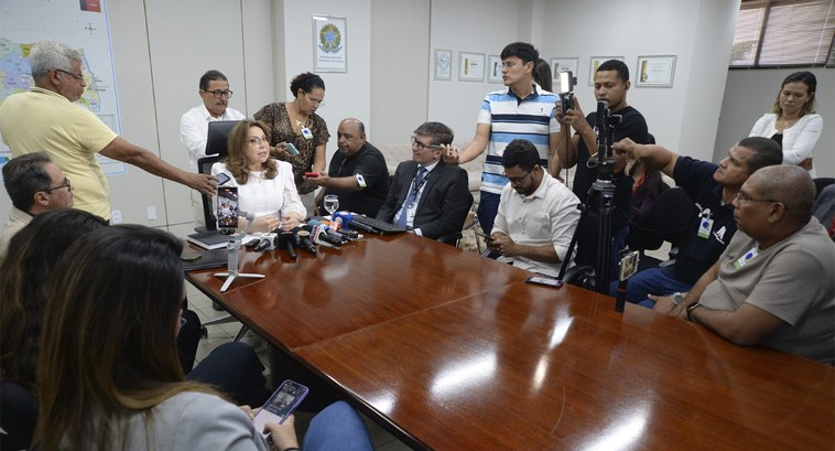 #PraTodosVerem: Na fotografia aparecem pessoas sentadas em volta de uma mesa, e outras em pé, co...