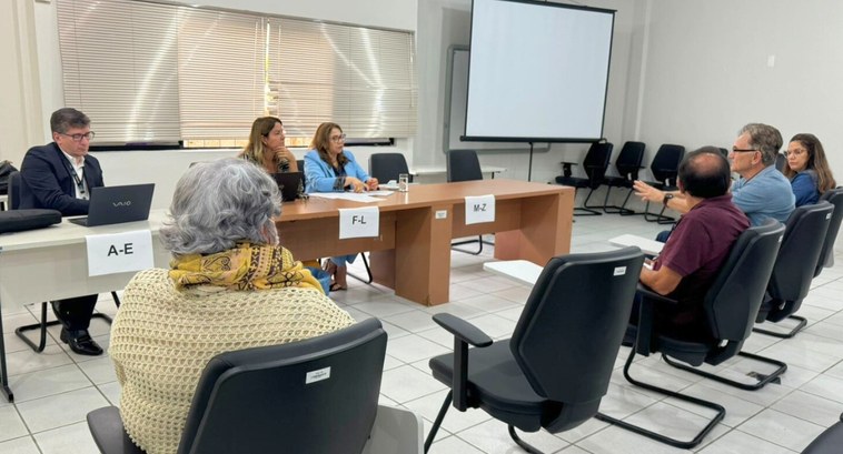 #PraTodosVerem: Na foto aparecem pessoas sentadas e em um auditório e, ao fundo, uma mesa de tra...