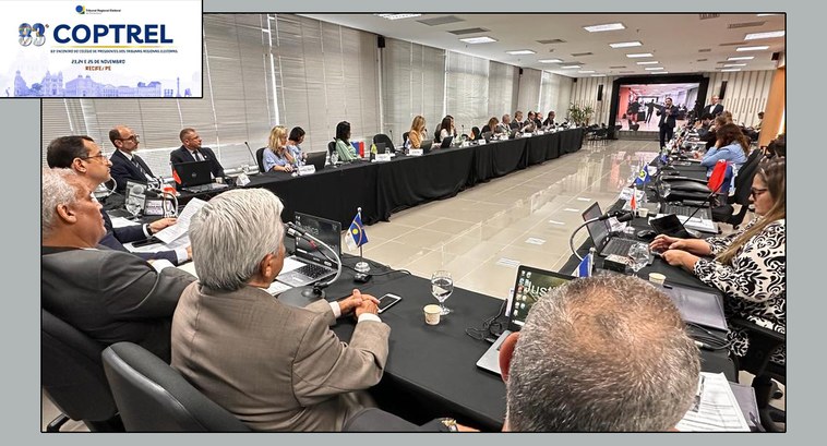 #ParaTodosVerem: Painel retangular com pessoas sentadas à mesa numa sala de reunião.