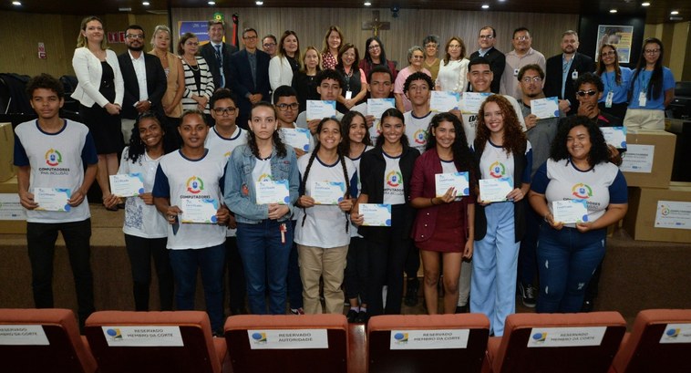 #PraTodosVerem: Na fotografia aparecem várias pessoas em pé, posando, na Sala de Sessões do Trib...