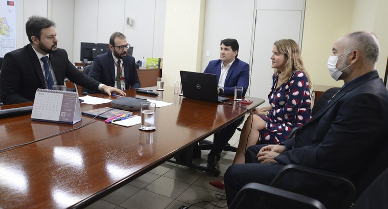 #ParaTodosVerem: Painel retangular, cinco pessoas, sendo uma mulher, sentadas em volta de uma me...