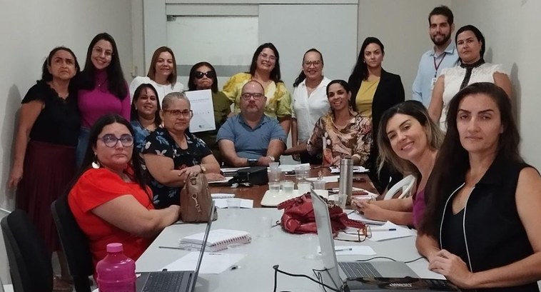 #PraTodosVerem: Na fotografia aparecem diversas mulheres e homens, em volta de uma mesa, alguns ...